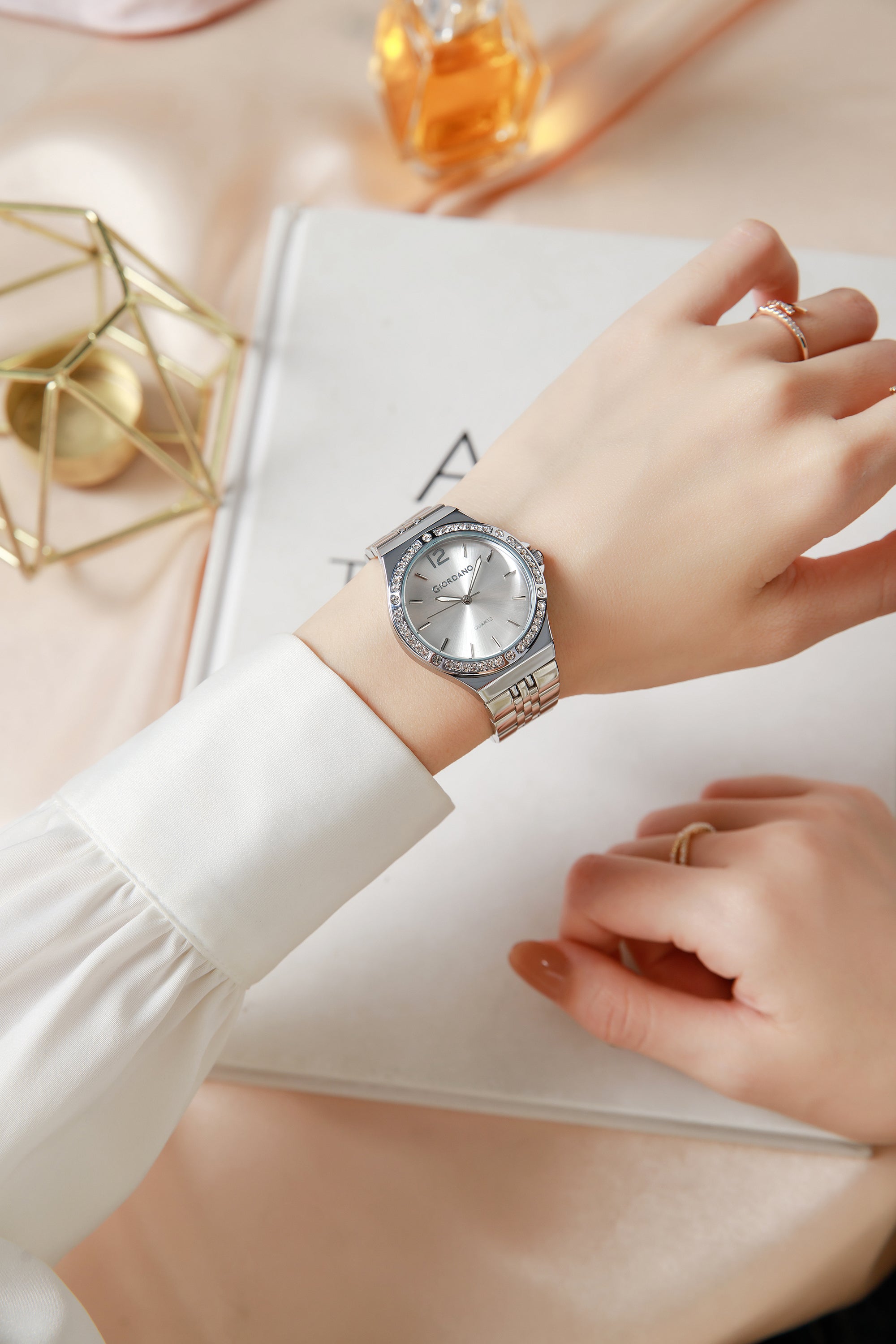 महिलाओं के लिए जिओरडनो एनालॉग क्वार्ट्ज़ वॉच जिसमें गोल सफेद डायल, क्रिस्टल स्टडेड बेज़ेल, नीला क्राउन, ल्यूमिनस हैंड्स, सिल्वर स्टेनलेस स्टील स्ट्रैप - GZ-60159-22